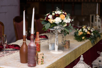 Flower arrangement on the wedding table with candles