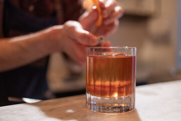 copo de Negroni sendo feito por barman.