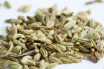 A close up macro photo of a pile of whole fennel seeds his popular spice is used in many cuisines from European cuisine to Indian Cuisine, isolated on a white background high quality photo - obrazy, fototapety, plakaty