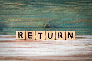 Return. Word from wooden blocks on a green and white background