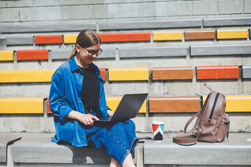 Portrait of cheerful freelance copywriter in optical eyewear glasses for vision protection smiling at camera - enjoying digital nomad lifestyle, happy Caucaisan IT professional with modern netbook