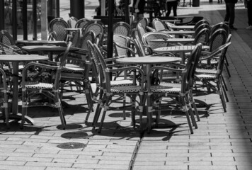 chairs and tables in front of a cafe in a city