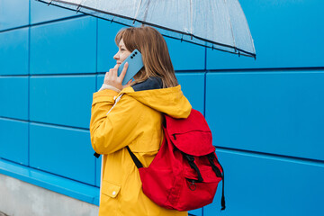 girl under an umbrella talking on a mobile phone