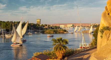 Fototapeta na wymiar Beautiful panorama landscape with felucca boats on Nile river in Aswan at sunset, Egypt