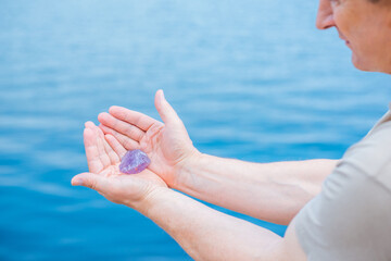 Quartz in hand, amethyst, alternative medicine. Energy therapy for mental healing