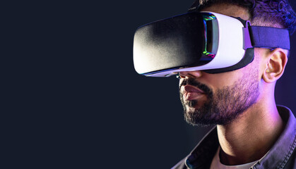 Young man using virtual reality headset, VR, future gadgets, technology, virtual event, education, learning, video game concept, Portrait of modern guy using vr glasses over black background - Powered by Adobe