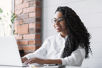 Young woman using laptop computer at office. Student girl working at home. Work or study from home, freelance, business, lifestyle concept