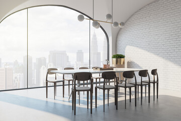 Side view on stylish dining table surrounded by wooden chairs on light floor in sunny room with brick wall and skyscrapers view from big arch window. 3D rendering