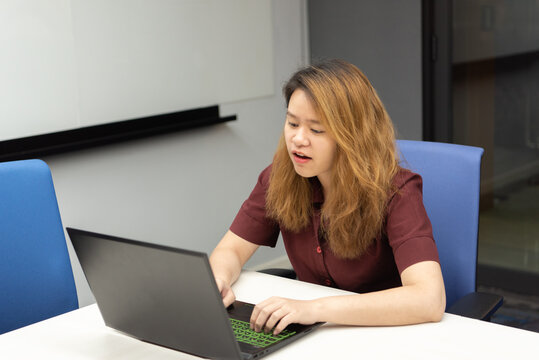 Woman working by laptop in office with happy