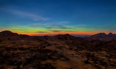Milky Way and colorful light at mountains. Night colorful landscape. Starry sky with hills. Beautiful Universe. Space background with galaxy. Travel background