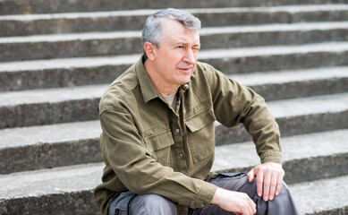 Mature European man with a good mood, outdoor portrait. The concept of life after 50 years	 