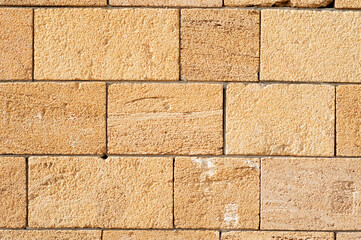 background, texture wall of facing brick of light brown non-uniform color close-up.