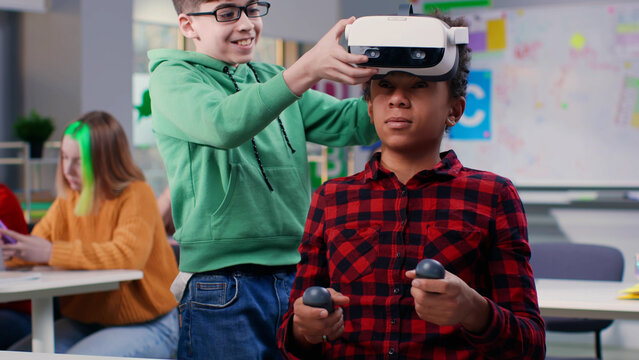 Schoolboy take off vr headset from classmate's head and laughing