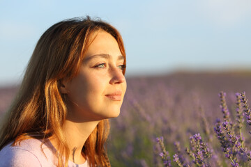 Woman relaxing contemplating sunset from lavender field