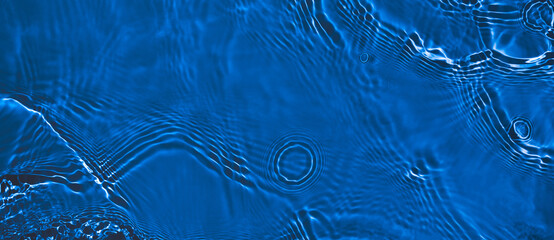 Transparent dark blue clear water surface texture with ripples and splashes. Abstract summer banner...