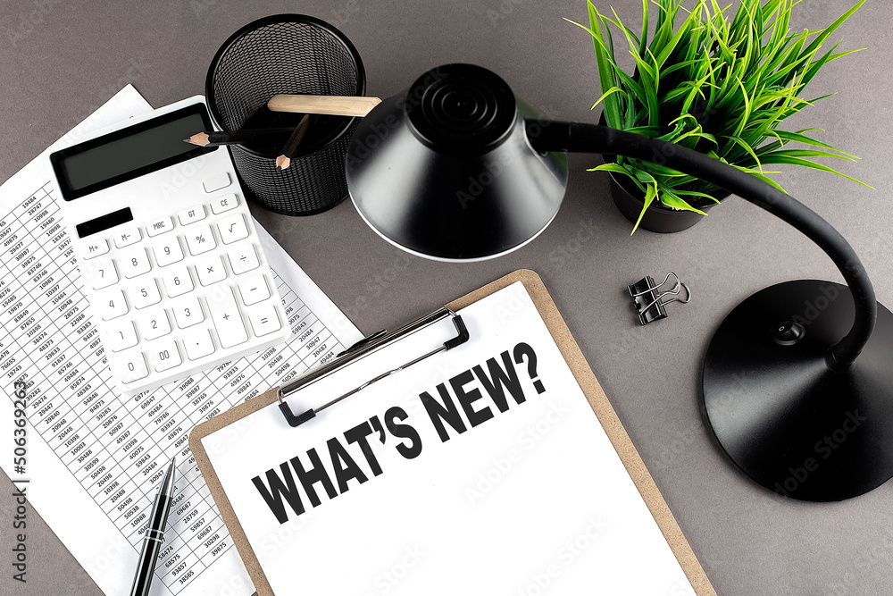 Poster clipboard ,chart and calculator, lamp and workspace accessories on a grey table. top view , text wha