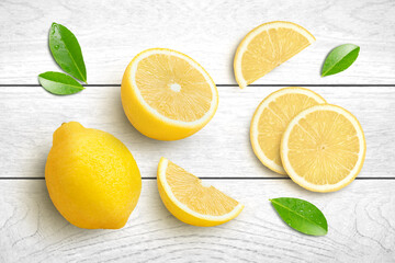 Whole and half sliced lemon with green leaf isolated on grey wooden table background. Top view. Flat lay.