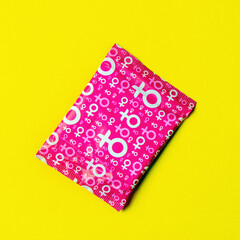Hygienic pad in the package close-up on a yellow background. Square image. space for text placement