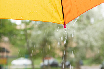 The edge of a colored umbrella and raindrops