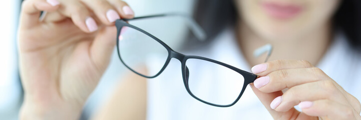 Woman holding glasses for vision, close-up