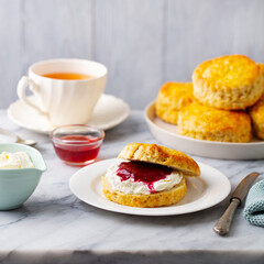 Scones with jam, clotted cream and cup of tea on marble table. Grey background. Close up. - 506370091