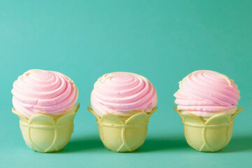 Pink cakes in a waffle cup on a vintage emerald background.