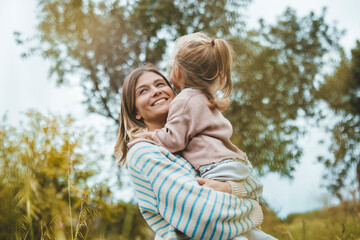 Happy mother embracing daughter in meadow