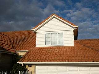 View of pitched roof dormer loft with window and concrete tiles