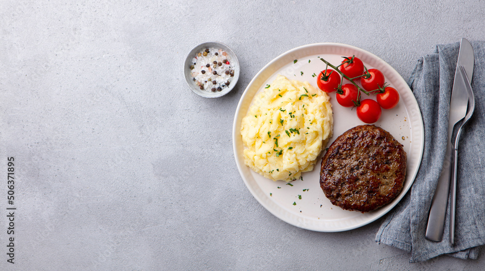 Wall mural beefsteak with mashed potato on a plate. grey background. copy space. top view.