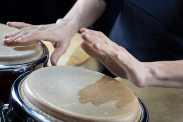 Hands of percussionist playing conga drum