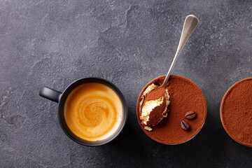 Tiramisu dessert with cup of coffee. Grey background. Copy space. Top view.