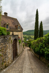 Fototapeta na wymiar narrow cobblestone street with quaint stone houses in the historic village of Beynac-et-Cazenac