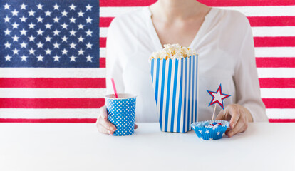 independence day, patriotism and holidays concept - close up of woman eating popcorn with drink and...