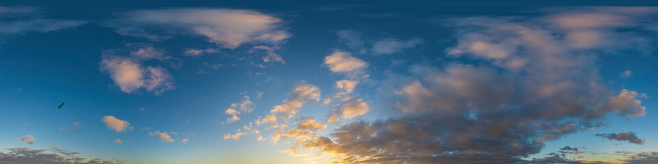 Obraz premium Panorama of a dark blue sunset sky with golden Cumulus clouds. Seamless hdr 360 panorama in spherical equiangular format. Full zenith for 3D visualization, sky replacement for aerial drone panoramas.