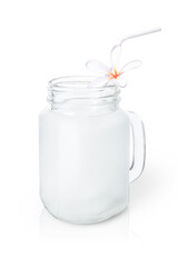 Glass jug of fresh coconut smoothie juice with straw and frangipani flower isolated on white background. Clipping path.