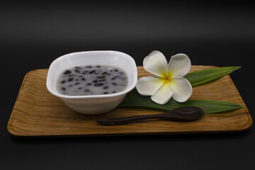 Thai dessert, black bean soup, sweet and delicious taste, white cup placed in a wooden tray,Include Clipping Path.