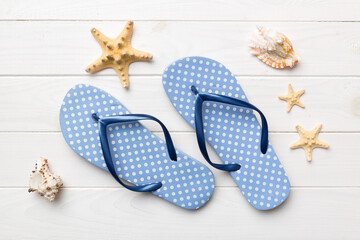 Flat lay composition with flip flops and seashell on colored background. Space for text top view