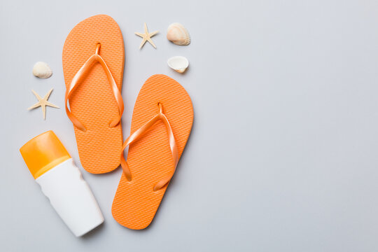 Summer travel concept. Beach accessories. Flip flops and starfish on white. Top view on colored background