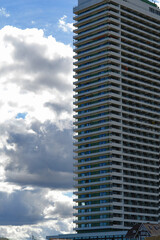 Profile of a hotel tower facing the clouds in sky.