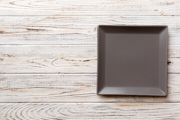 Top view of empty square plate on wooden background. Empty space for your design