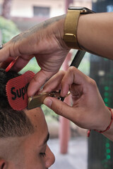 Young handsome man in barbershop having a haircut