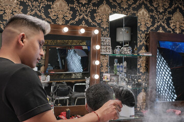 Young handsome man in barbershop having a haircut