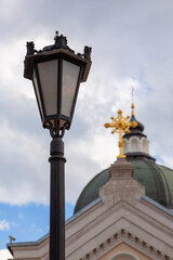 Antique street lamp against the background of the dome of the Orthodox Church