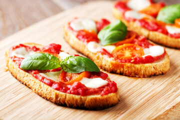 Italian appetizer bruschetta with Tomato sauce, Mozzarella and fresh Basil on a plate