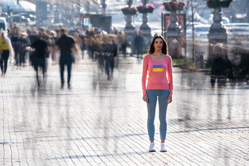 The woman stands in the middle of crowded street.