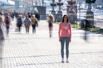 The woman stands in the middle of crowded street.