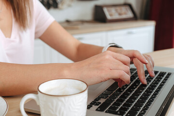 Businesswoman hand working at a home. woman using laptop, female hands typing, writing notes,...