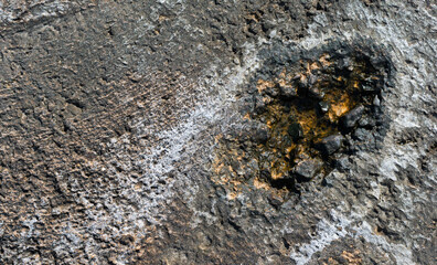 Texture of a hole in a rock caused by sea erosion with a layer of salt. Abstract and minimalist background.