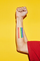 Vibrant shot of arm in fist with rainbow flag tattoo as power symbol for pride month LGBTQ