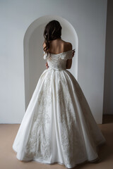 Fototapeta premium Beautiful bride posing in wedding dress in a white photo Studio.